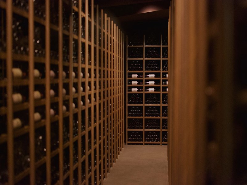 Aplicação Palazzo Cave a mostrar um alerta de temperatura, junto a uma cave de vinhos
